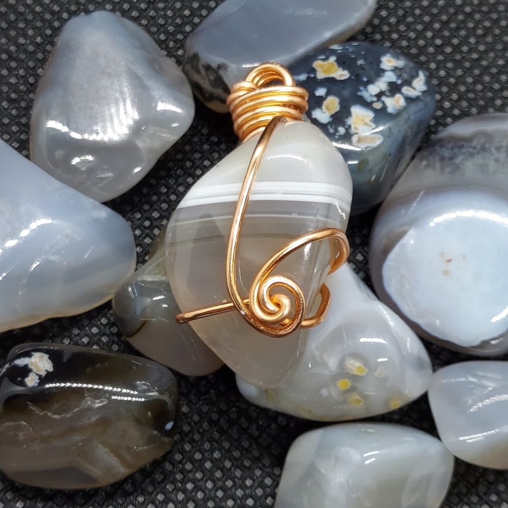 Wire wrapped polished agate necklace pendant.